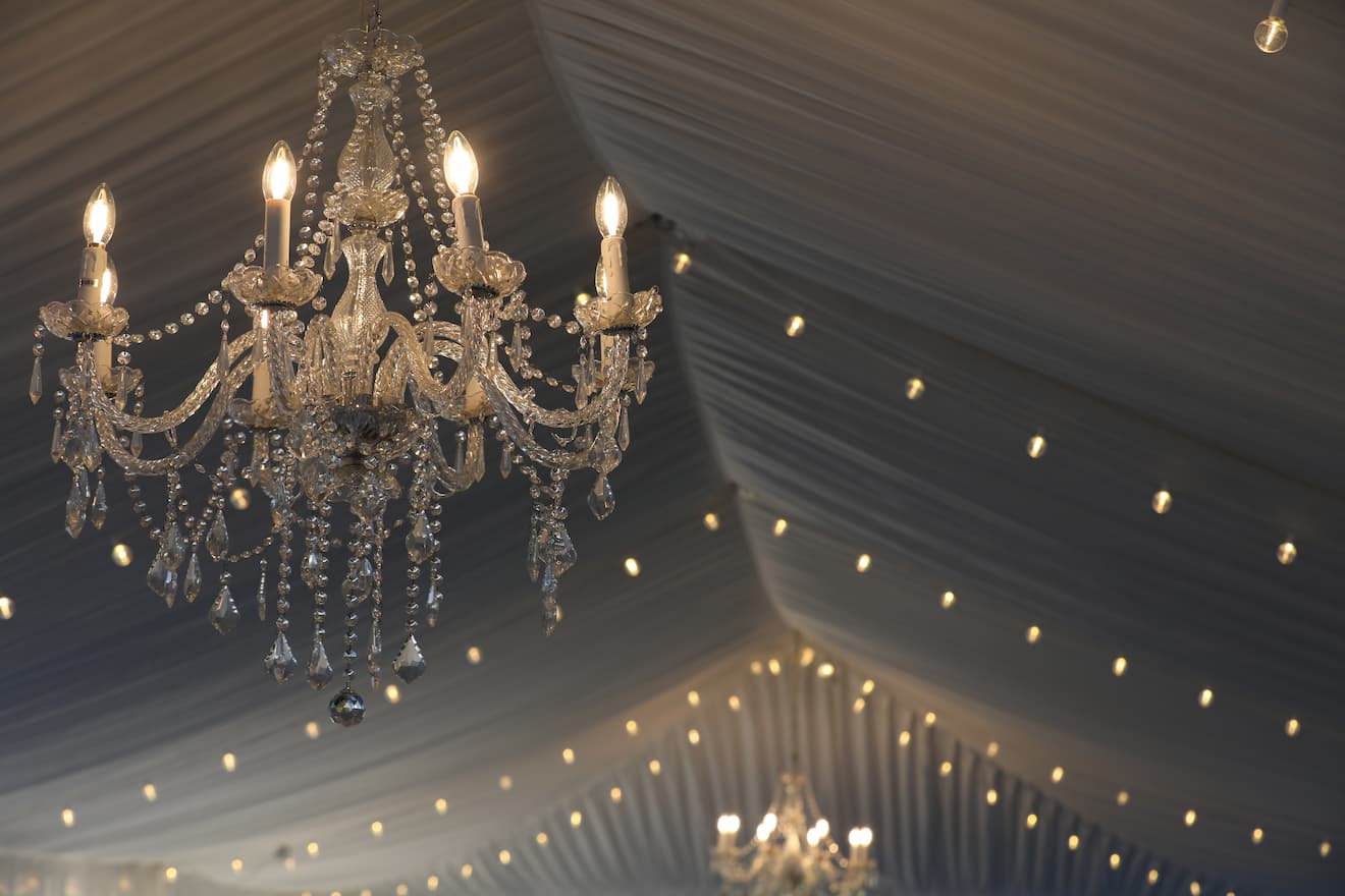 a crystal chandelier in a wedding tent