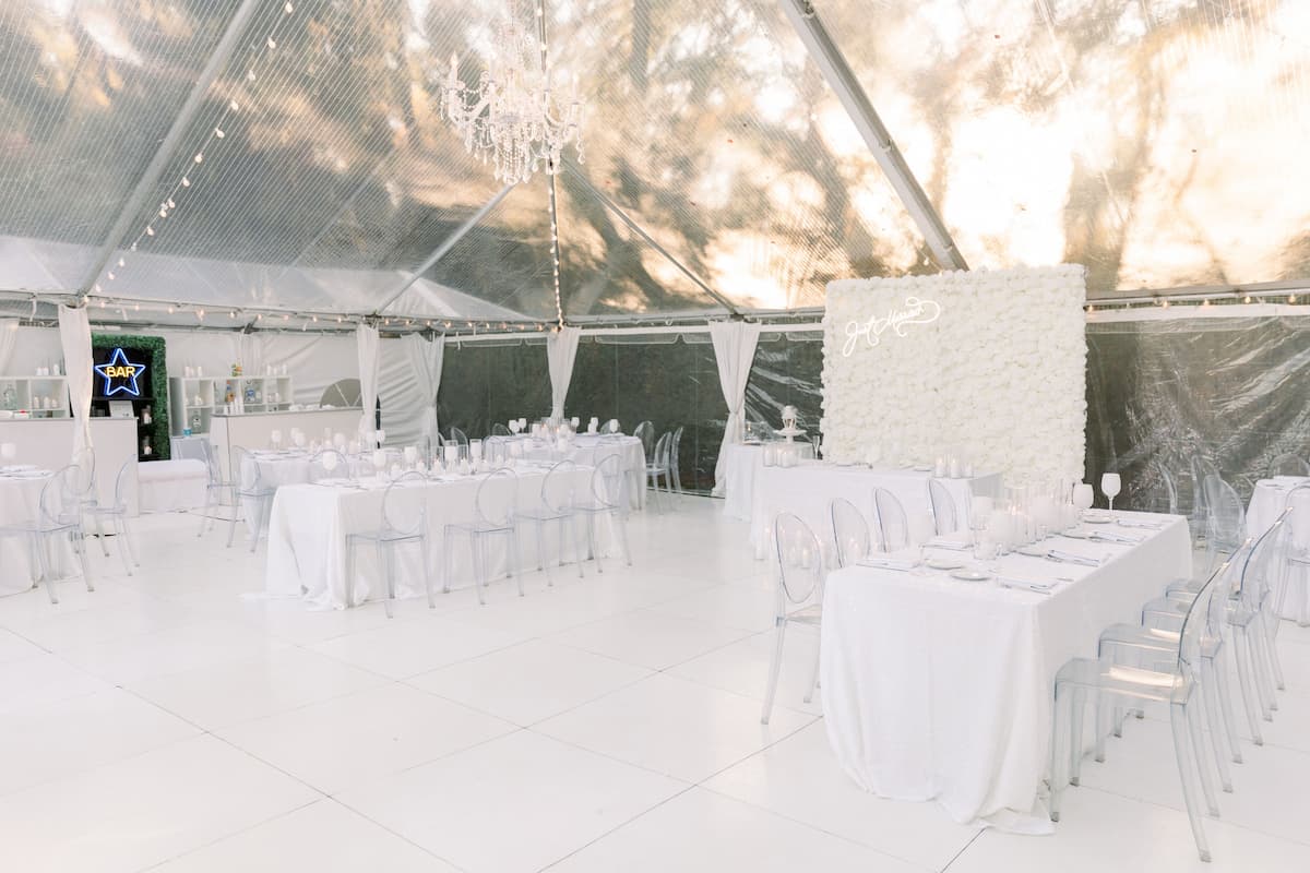 A white floor set up under a wedding tent