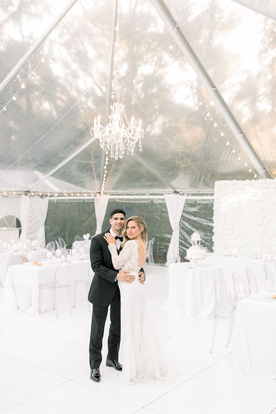 a bride and groom under a wedding tent