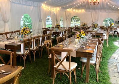 a rustic wedding tent, with lighting inside and tables and chairs