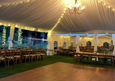 a rustic wedding tent, with lighting inside