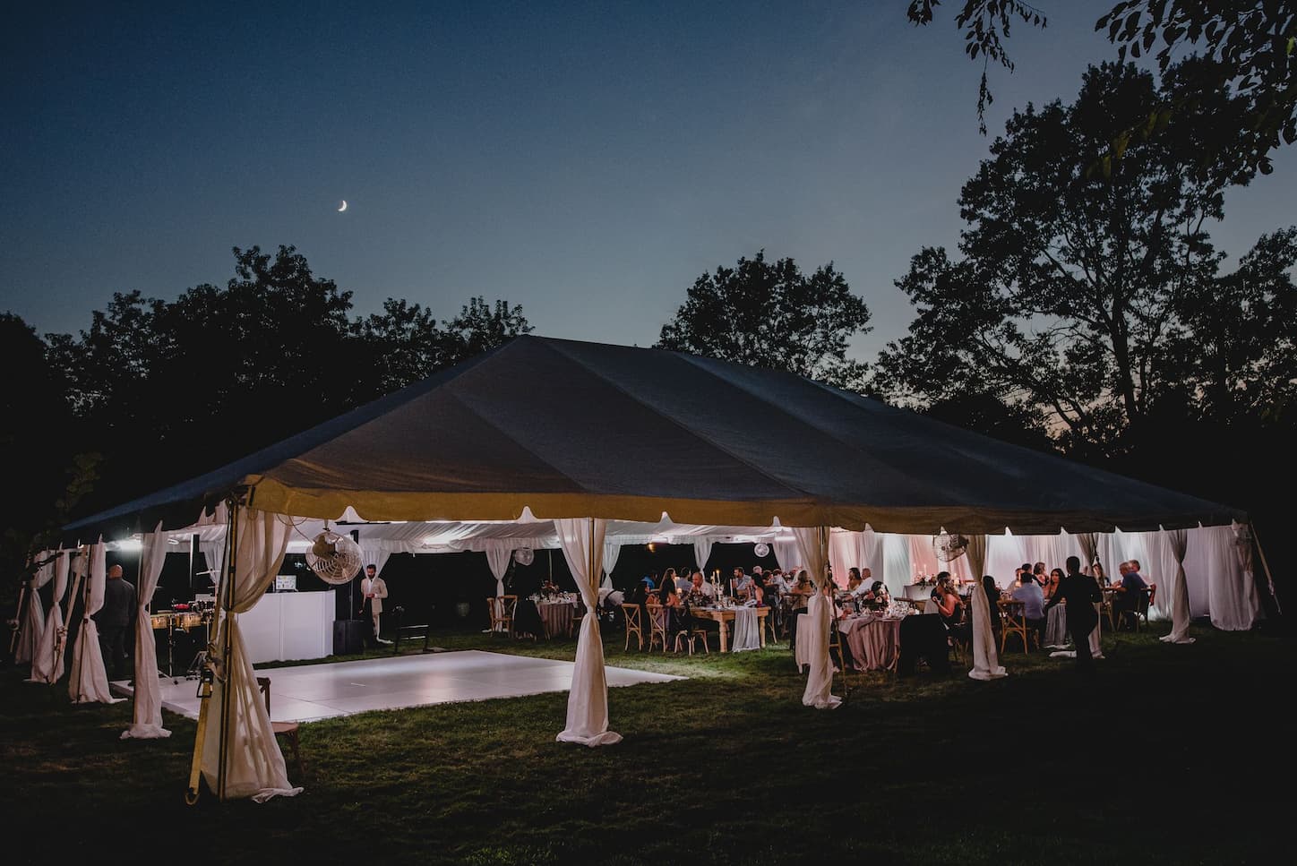 an outdoor wedding tent lit up at night